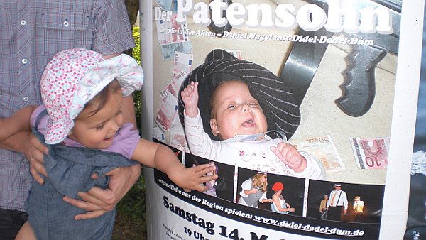 Der Patensohn: Litfasssäule mit Plakat und Baby